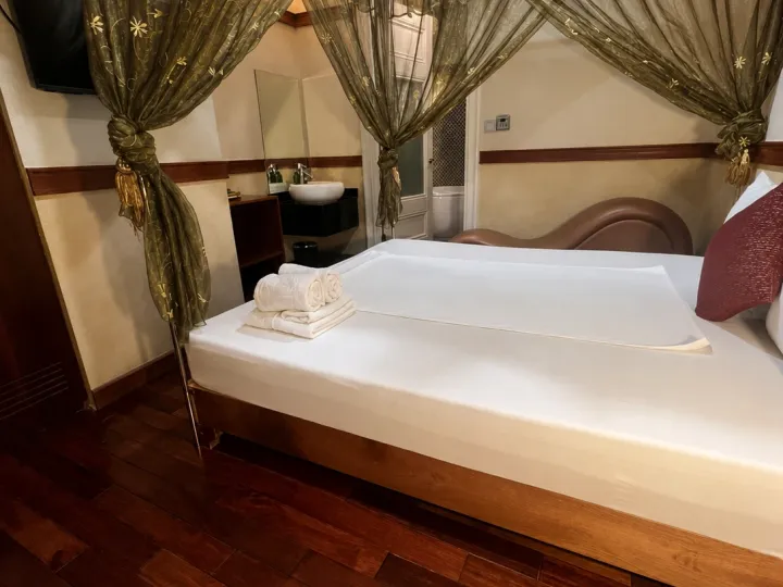 Samdi Hotel 청룡이발소의 캐노피 침대와 세면대가 있는 프라이빗 룸