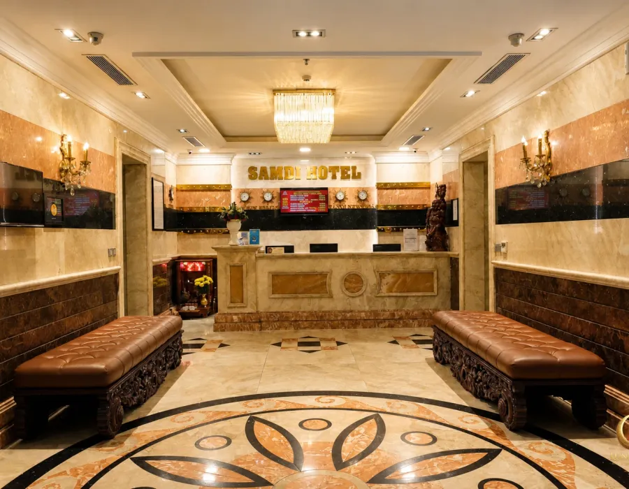 금색 SAMDI HOTEL 표지와 대리석 데스크가 보이는 청룡이발소 건물 로비