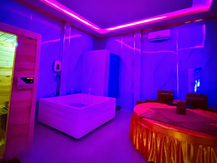 원형 베드·욕조·목재 사우나가 함께 있는 보니 마사지 룸